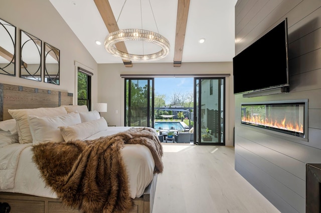 bedroom with a glass covered fireplace, recessed lighting, wood finished floors, and access to exterior