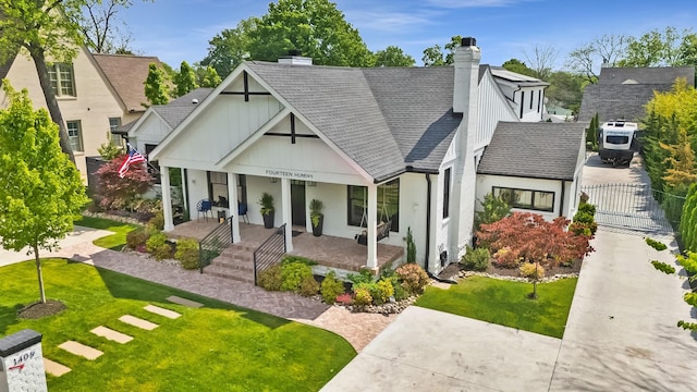exterior space with a lawn, fence, roof with shingles, a chimney, and a porch