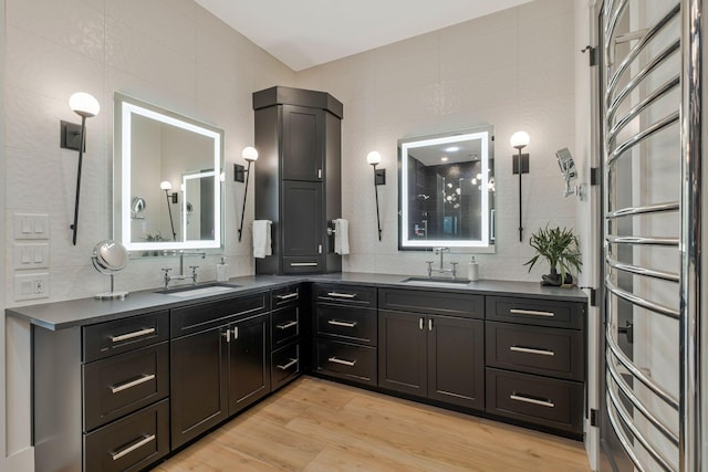 full bath with a sink, decorative backsplash, and double vanity