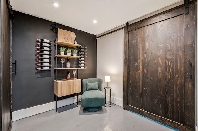 living area featuring baseboards, recessed lighting, a barn door, and finished concrete floors