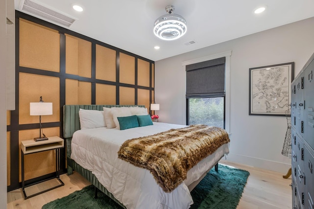 bedroom with recessed lighting, baseboards, light wood-type flooring, and visible vents