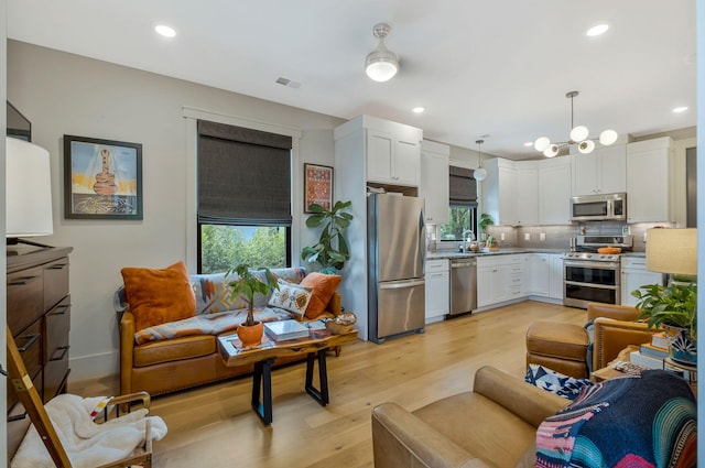 living room with visible vents, recessed lighting, and light wood-style floors