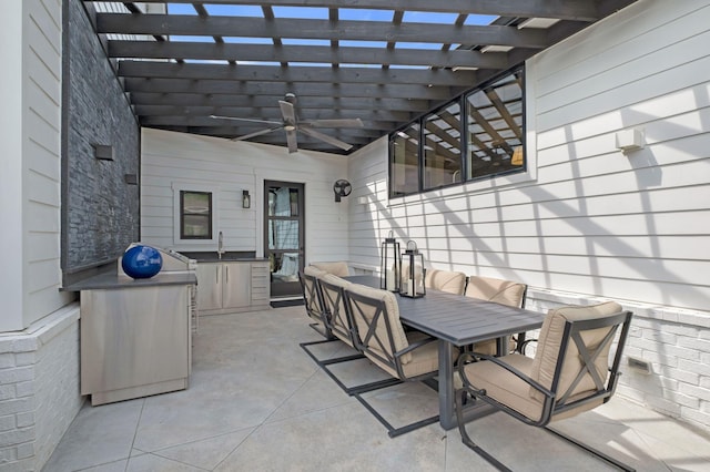 view of patio featuring outdoor dining area, ceiling fan, a sink, and a pergola