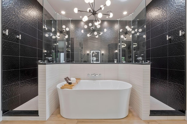 full bathroom featuring walk in shower, tile walls, and a chandelier