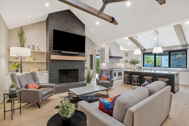 living room featuring light wood-type flooring, ceiling fan, and vaulted ceiling with beams