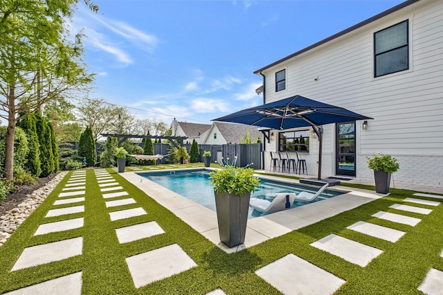 view of swimming pool with a yard, fence, a fenced in pool, and a patio