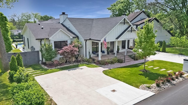view of front of property featuring a porch, board and batten siding, roof with shingles, and a chimney