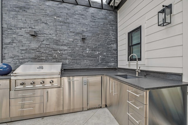 kitchen featuring a sink, light tile patterned floors, dark countertops, and high quality fridge