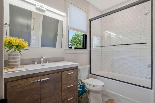bathroom featuring vanity, combined bath / shower with glass door, and toilet