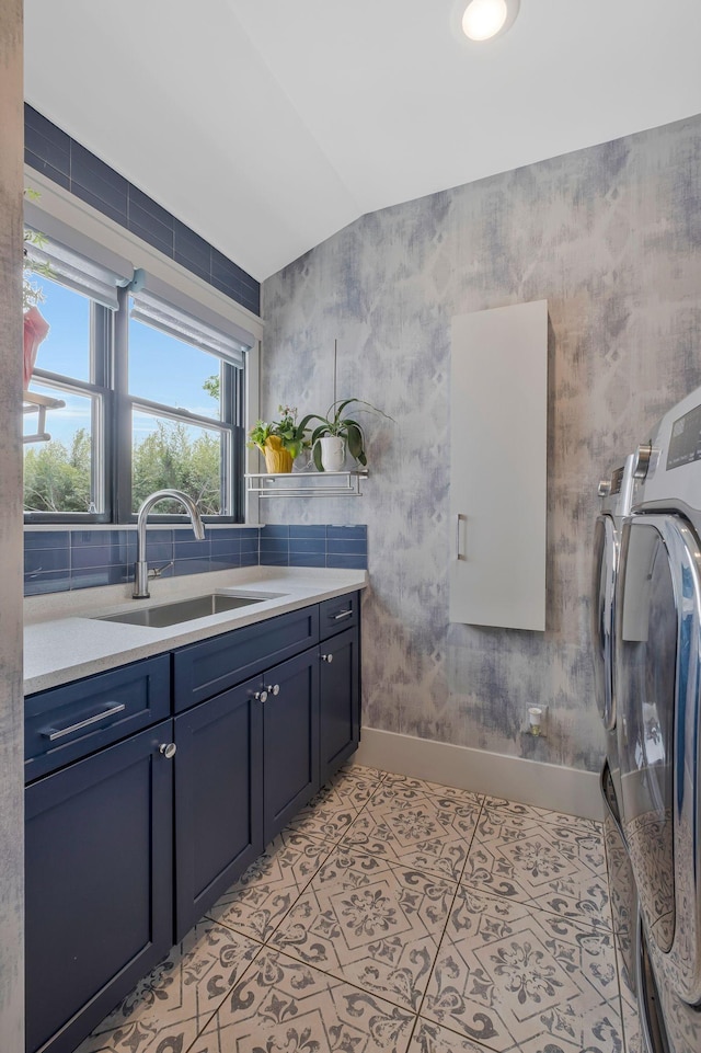 bathroom featuring a sink, baseboards, and independent washer and dryer