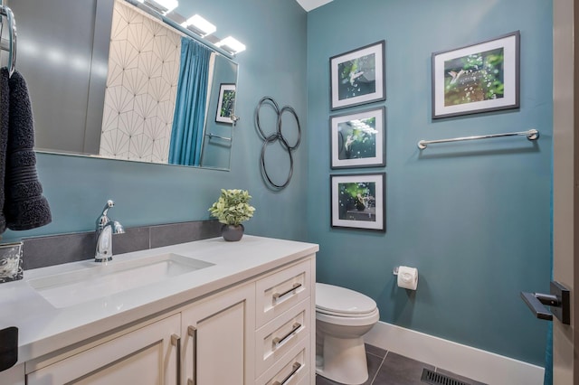 bathroom with vanity, toilet, tile patterned floors, baseboards, and visible vents