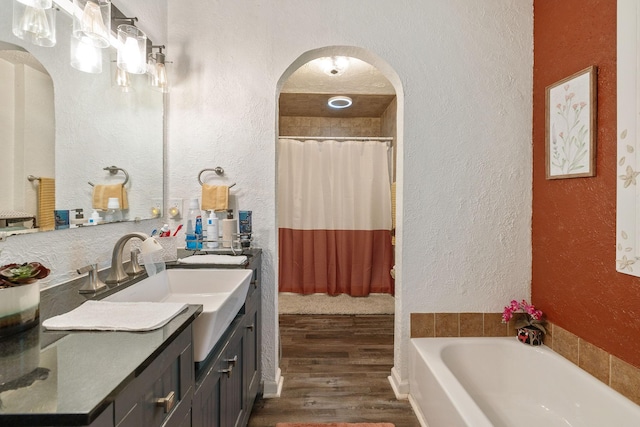 12817 Lascassas Pike, Milton, TN 37118 - bathroom with a textured wall, vanity, a shower with shower curtain, a washtub, and wood finished floors