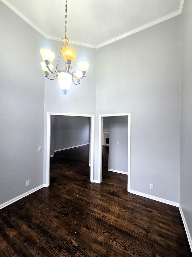 unfurnished dining area with an inviting chandelier, baseboards, ornamental molding, and dark wood-style floors