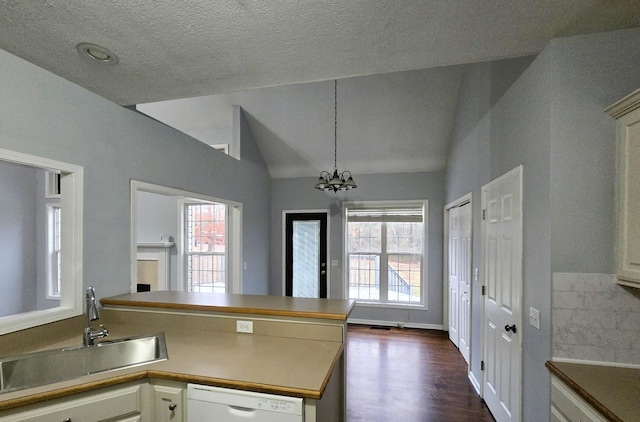 kitchen featuring a sink, a peninsula, dishwasher, and a healthy amount of sunlight