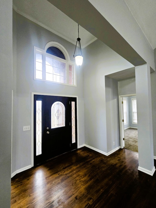 foyer with dark wood-style flooring, baseboards, and ornamental molding