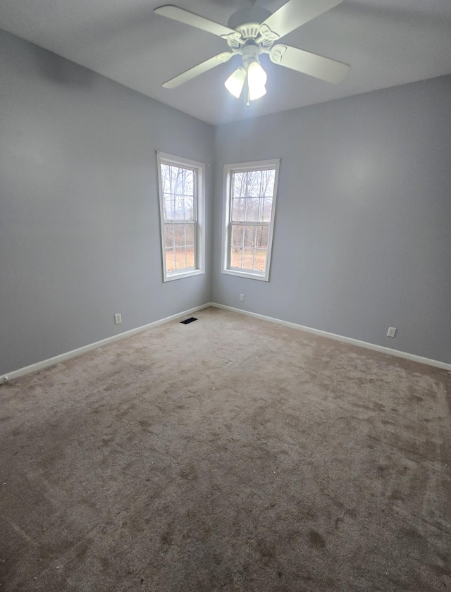 unfurnished room featuring baseboards, carpet flooring, a ceiling fan, and visible vents
