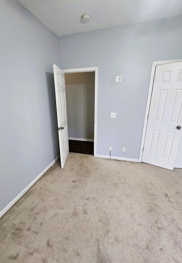 empty room featuring baseboards and carpet