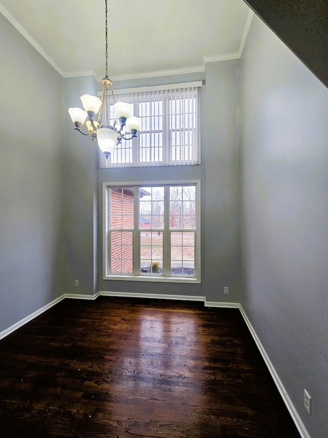empty room featuring an inviting chandelier, ornamental molding, and a wealth of natural light