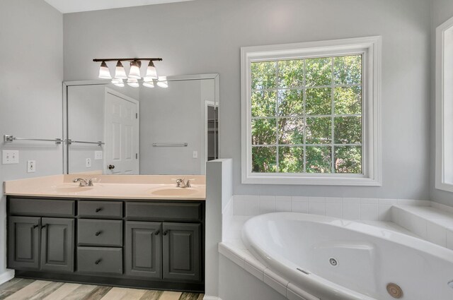 1031 Laurel Hill Dr, Dickson, TN 37055 - full bathroom featuring healthy amount of natural light, a whirlpool tub, double vanity, and wood finished floors