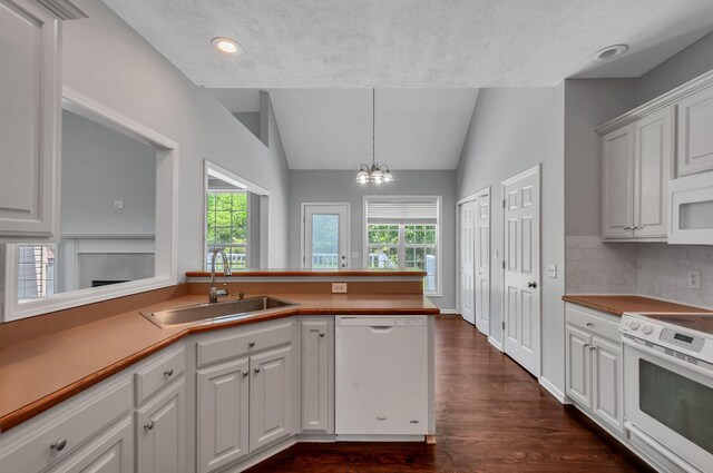 1031 Laurel Hill Dr, Dickson, TN 37055 - kitchen featuring white appliances, a sink, vaulted ceiling, dark wood-style floors, and a chandelier