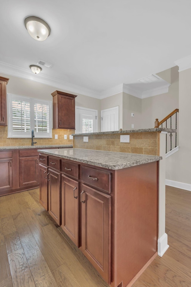 1020 Rural Plains Cir, Franklin, TN 37064 - kitchen featuring backsplash, light stone counters, light wood-type flooring, and a center island
