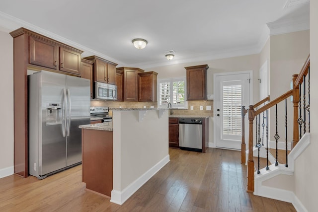 1020 Rural Plains Cir, Franklin, TN 37064 - kitchen with light stone countertops, appliances with stainless steel finishes, decorative backsplash, and light wood-type flooring