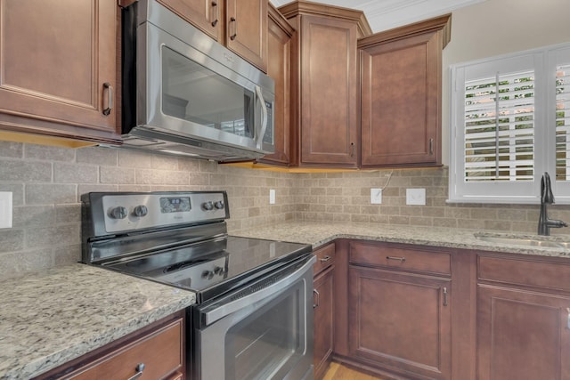 1020 Rural Plains Cir, Franklin, TN 37064 - kitchen with light stone countertops, a sink, brown cabinetry, stainless steel appliances, and backsplash
