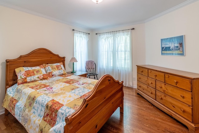 bedroom featuring baseboards, ornamental molding, and wood finished floors