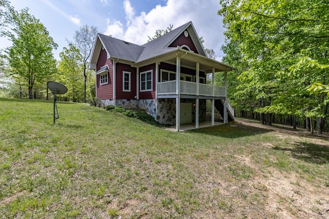 back of house with a lawn, a deck, a shingled roof, and stairs