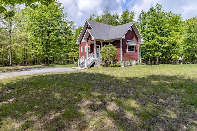 view of front of property with a front yard and a forest view