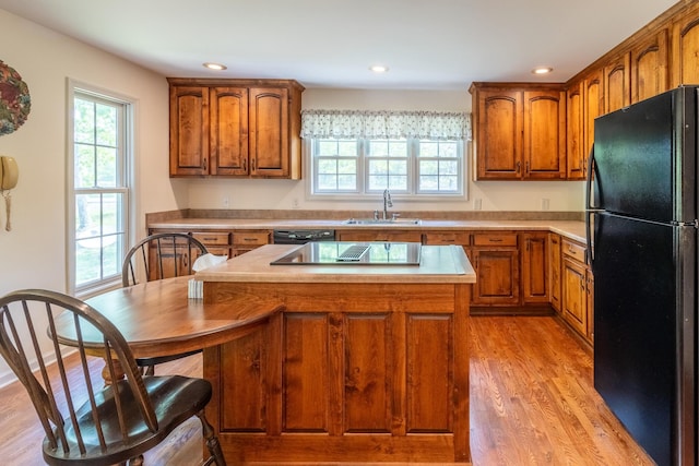 kitchen with a sink, brown cabinets, and black appliances