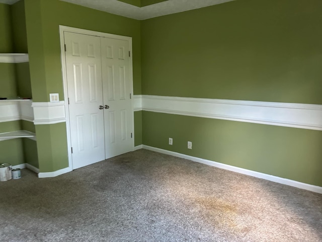 unfurnished bedroom featuring carpet floors, baseboards, and a closet