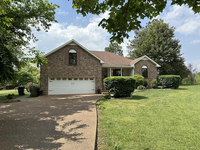 view of front of property with brick siding, a garage, a front lawn, and driveway