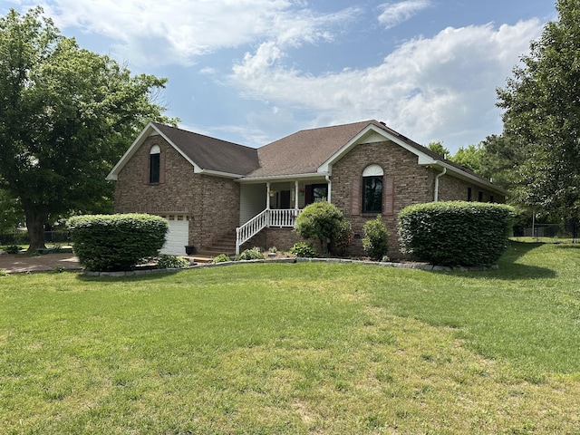view of front facade with an attached garage, a front lawn, and brick siding