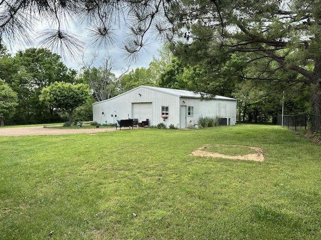 view of pole building featuring fence and a yard