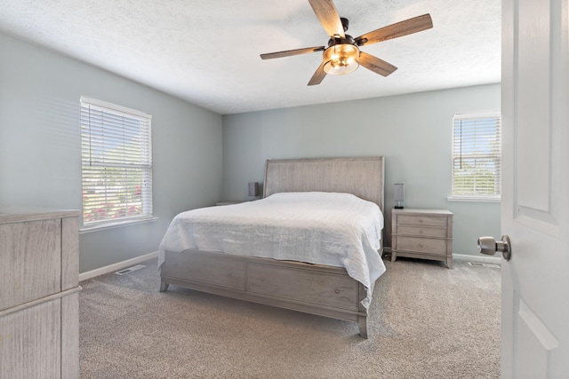 bedroom featuring baseboards, carpet, visible vents, and multiple windows