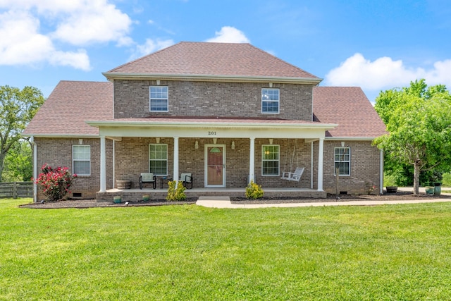view of front of home featuring a porch, a front yard, roof with shingles, brick siding, and fence
