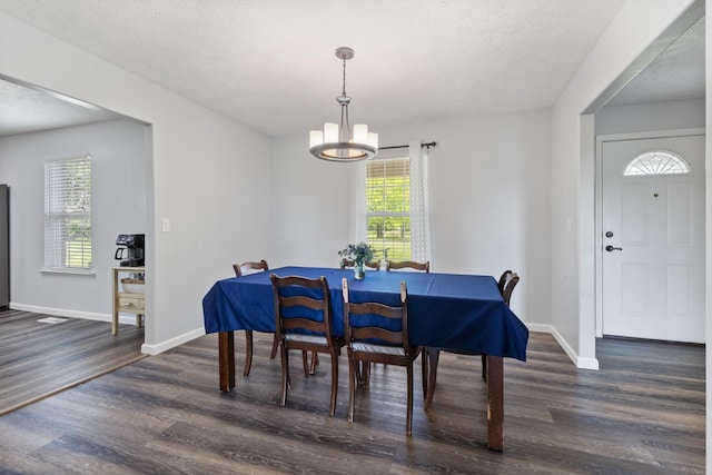 dining area with baseboards, wood finished floors, and a notable chandelier