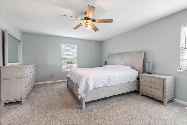 bedroom with baseboards, ceiling fan, and light carpet
