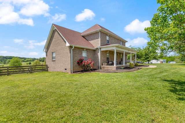 back of house with fence, roof with shingles, brick siding, crawl space, and a yard