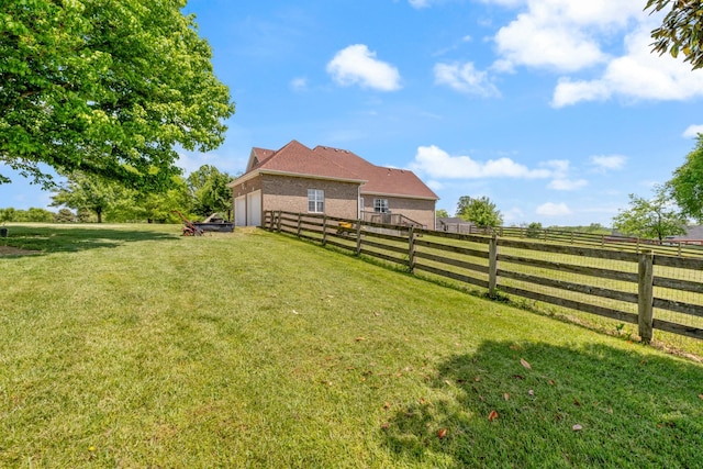 view of yard with a garage and a fenced backyard