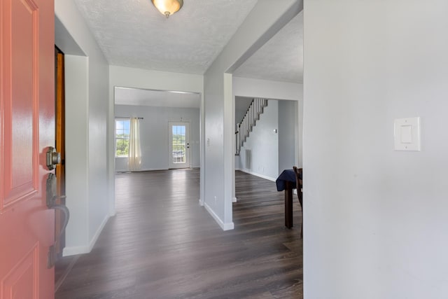 entryway featuring stairway, baseboards, dark wood finished floors, and a textured ceiling
