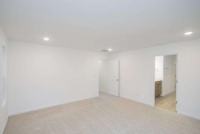 spare room with light colored carpet, recessed lighting, and baseboards