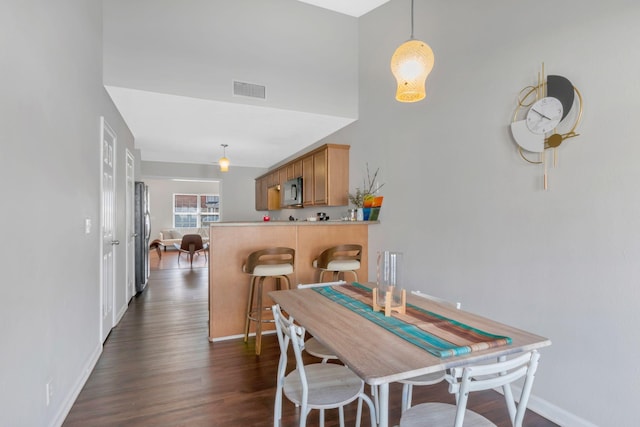 dining space with dark wood-type flooring, baseboards, and visible vents