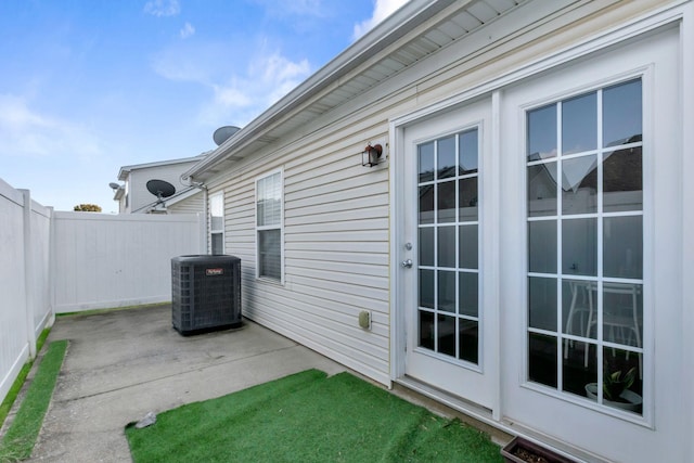 view of patio with central air condition unit and fence