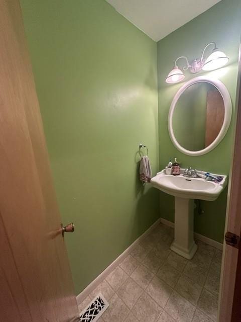 bathroom with a sink, baseboards, and visible vents