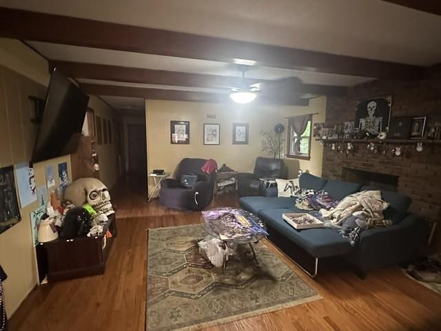living room featuring a fireplace, beam ceiling, and wood finished floors