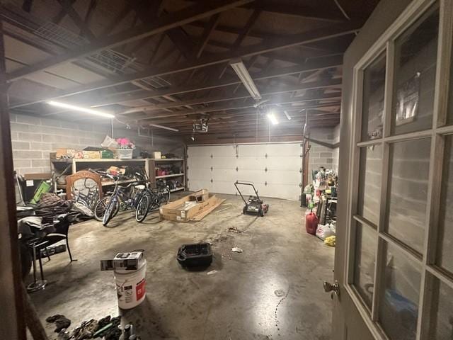 garage featuring concrete block wall and a garage door opener