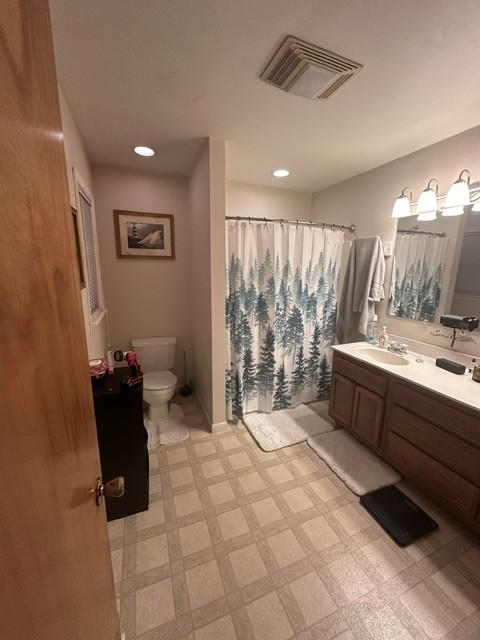 bathroom featuring toilet, tile patterned floors, visible vents, and vanity