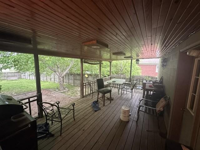 deck featuring a lawn, a fenced backyard, and outdoor dining space
